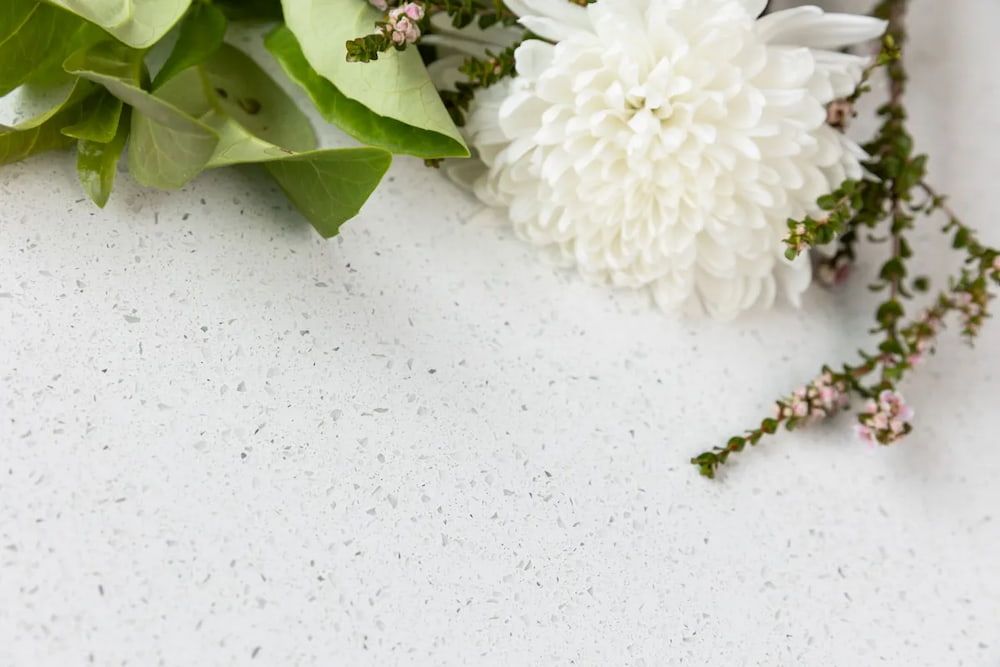 A Bouquet of White Flowers and Green Leaves on a White Surface — Better Stone in Caloundra West, QLD