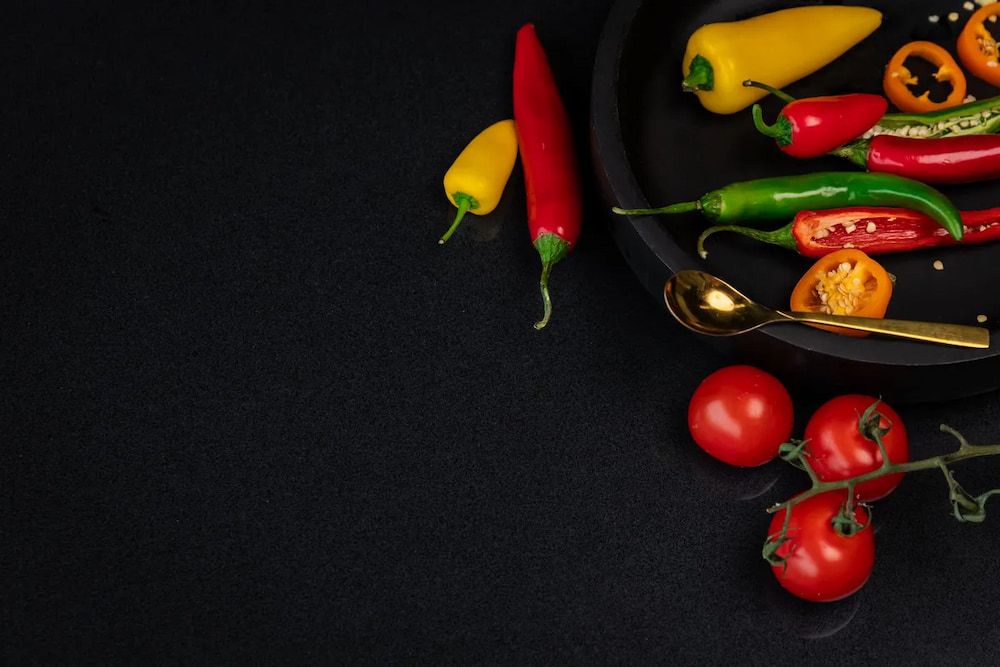 There Are Many Different Types of Peppers and Tomatoes on a Black Plate — Better Stone in Caloundra West, QLD