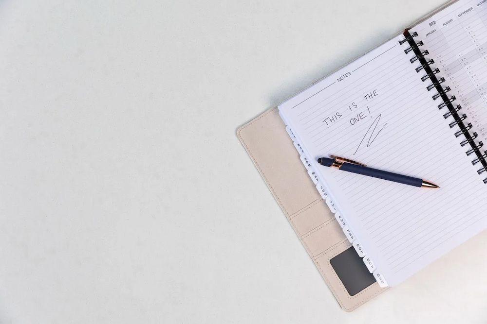 A Pen is Sitting on Top of a Notebook on a Table. — Better Stone in Caloundra West, QLD