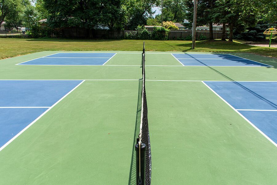 A blue and green tennis court with a net in the middle