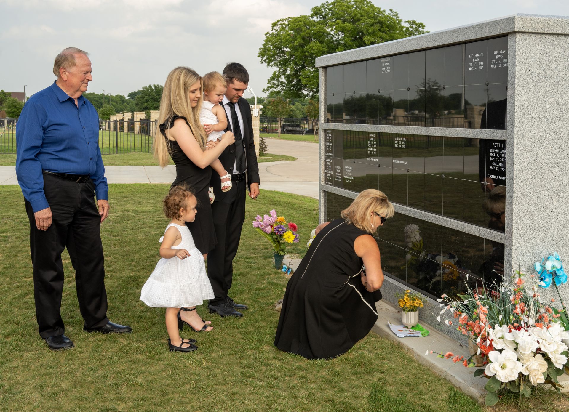 A columbarium in New Hope Memorial Gardens with a family sitting beside it