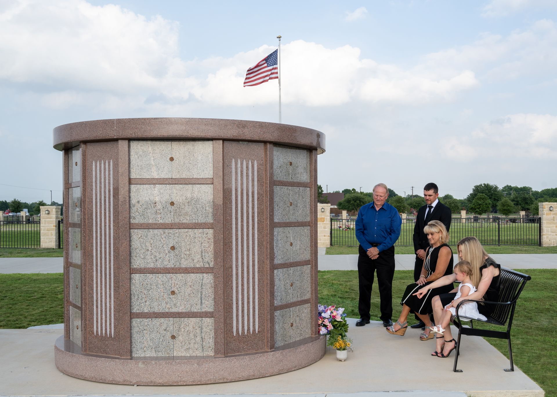 A columbarium in New Hope Memorial Gardens with a family sitting beside it
