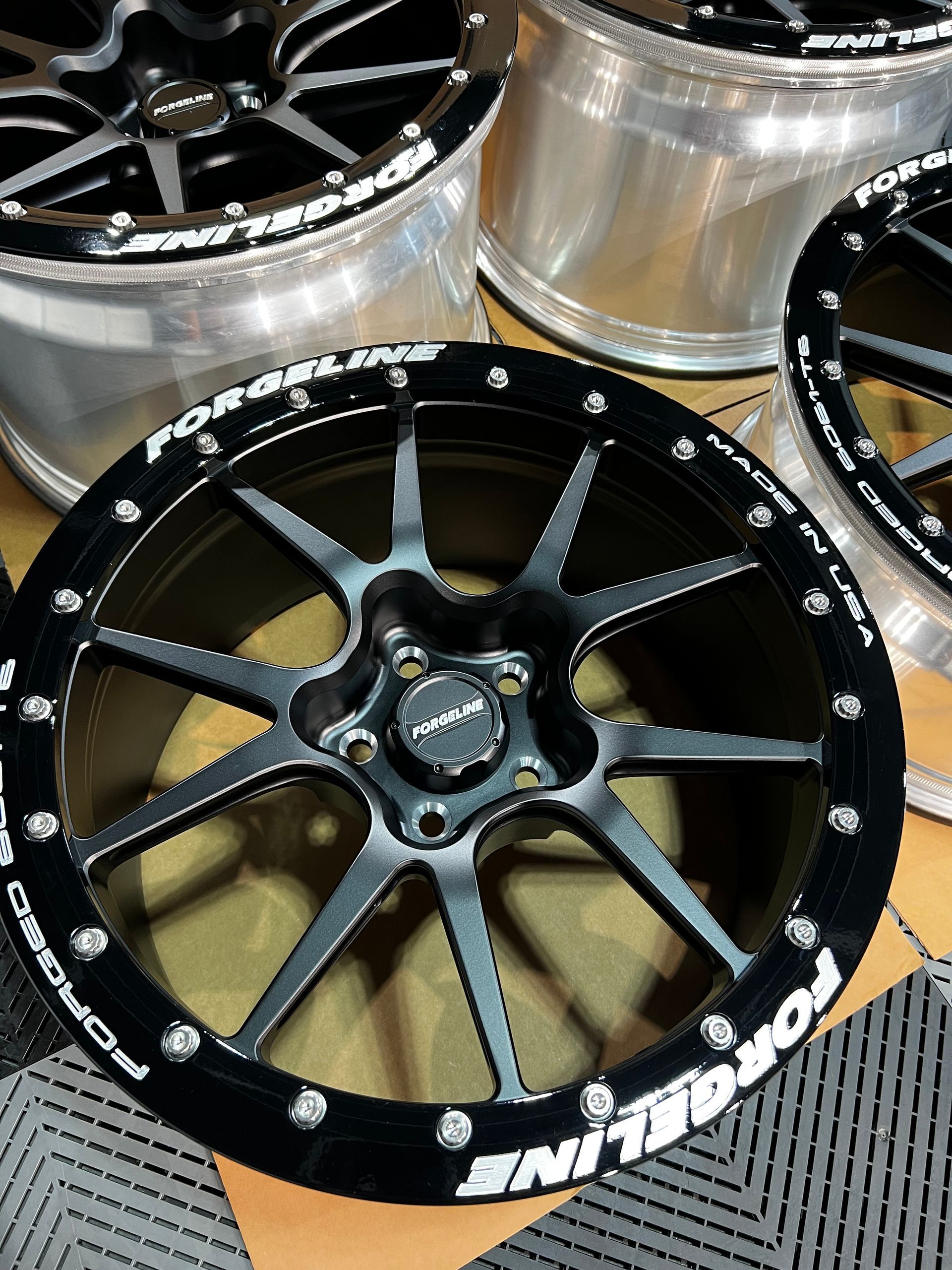 A group of forged wheels are sitting on top of each other on a table.