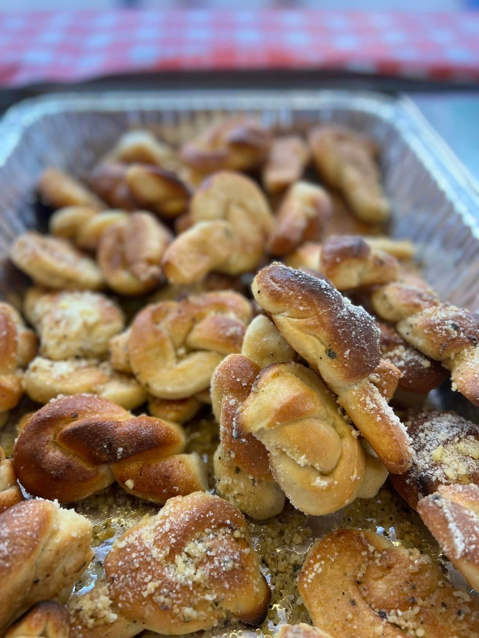 a close up of a tray of garlic knots on a table .