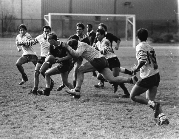A black and white photo of a group of men playing rugby