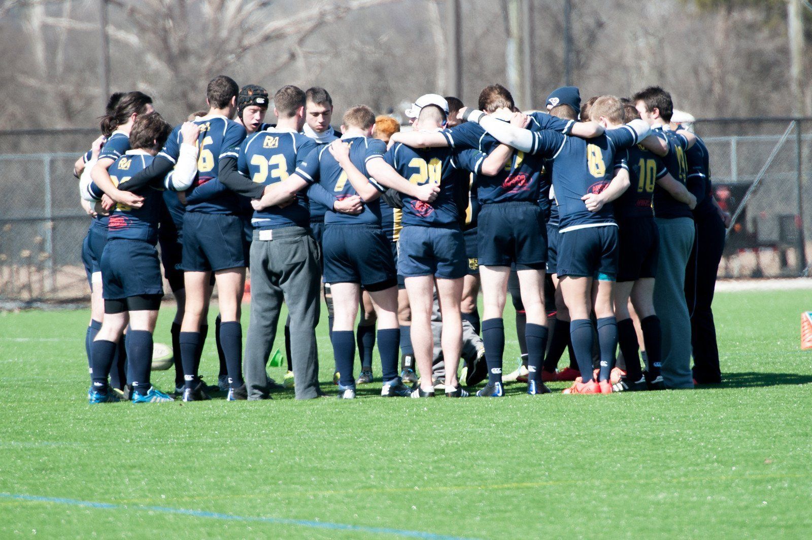 A group of soccer players are huddled together on a field
