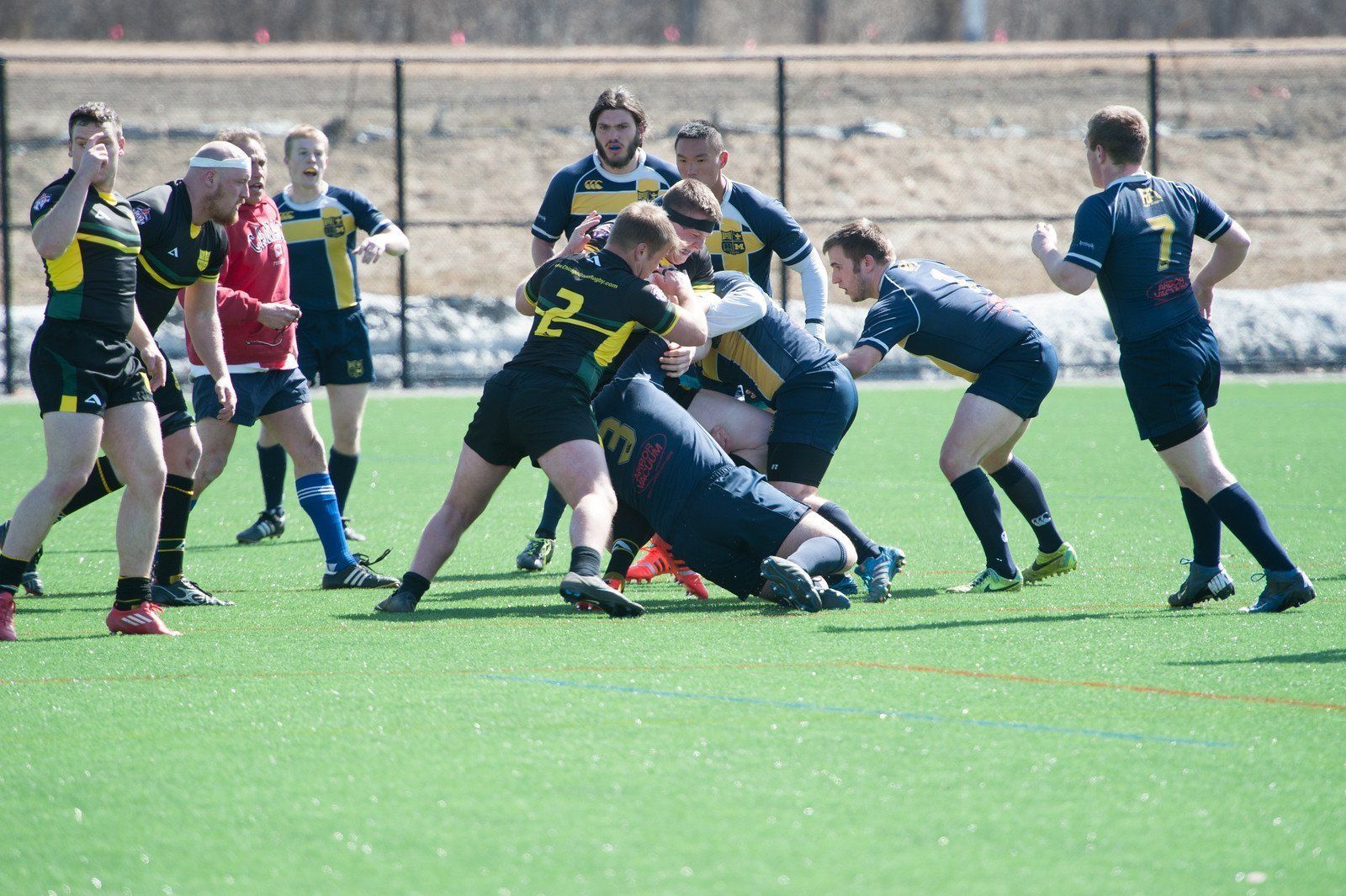 A group of rugby players are playing a game on a field.