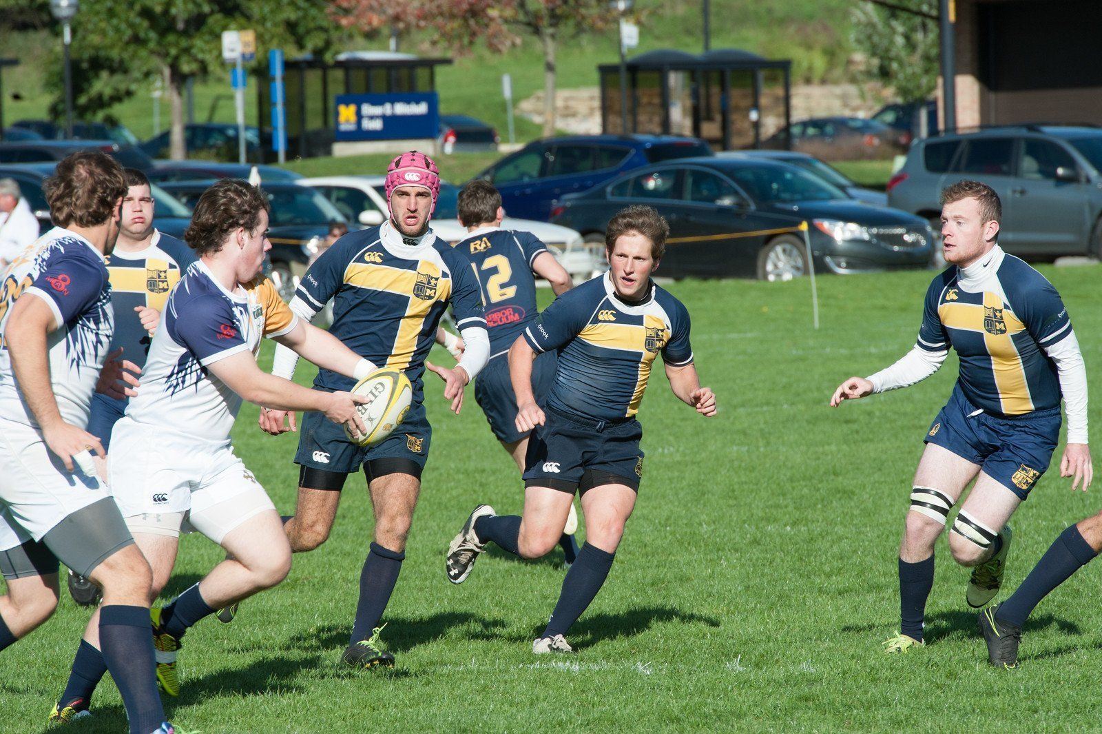 A group of men are playing a game of rugby on a field.