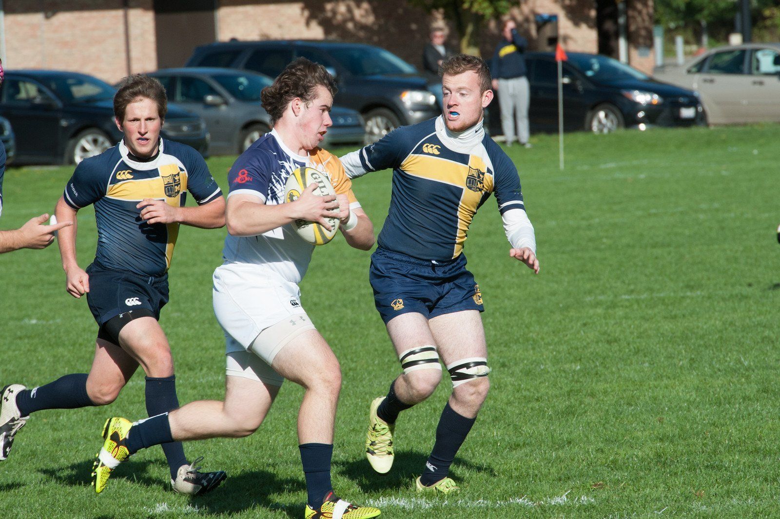 A group of young men are playing rugby on a field.