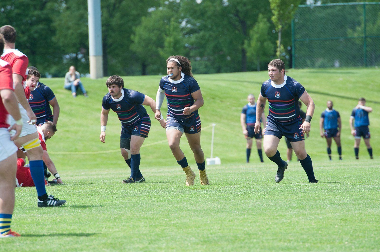 A group of men are playing rugby on a field.