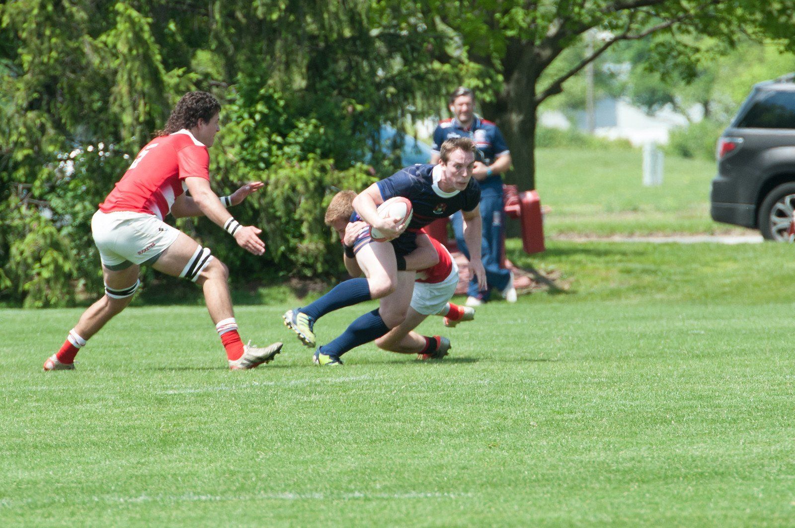 A group of people are playing rugby on a field.