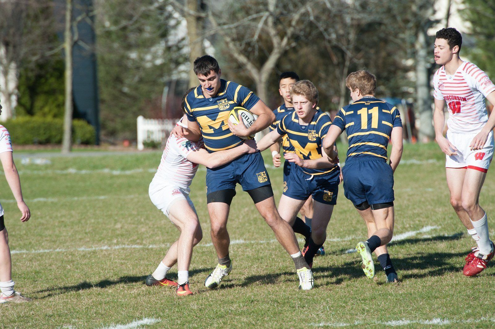 A group of young men are playing rugby on a field.