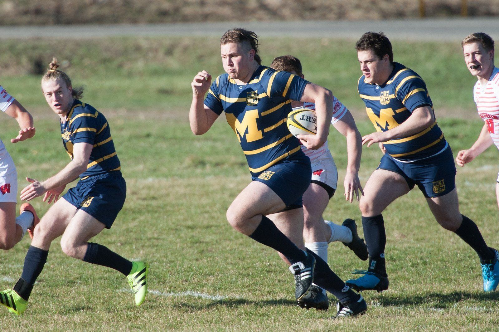 A group of people are playing rugby on a field.