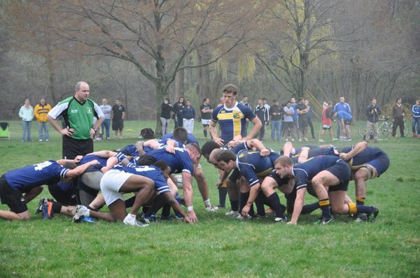 A group of rugby players are huddled together on a field