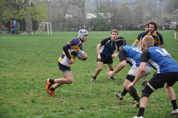 A group of young men are playing rugby on a field.