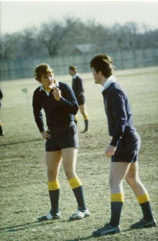 Two men standing on a field talking to each other