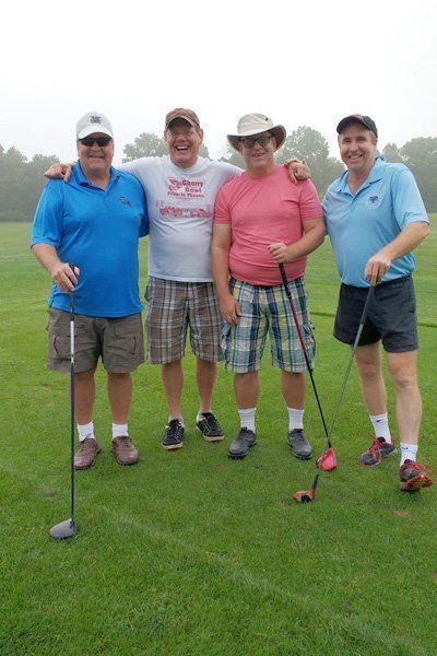 A group of men are posing for a picture on a golf course.