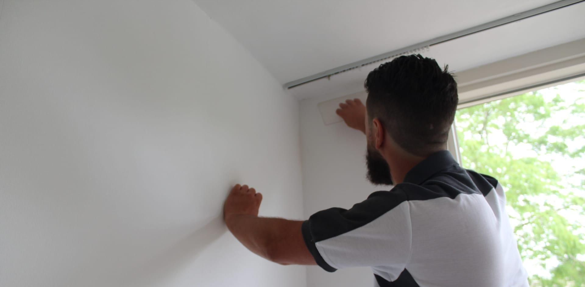 Professionele schilder en behanger in Doetinchem die een muur aan het afwerken is.