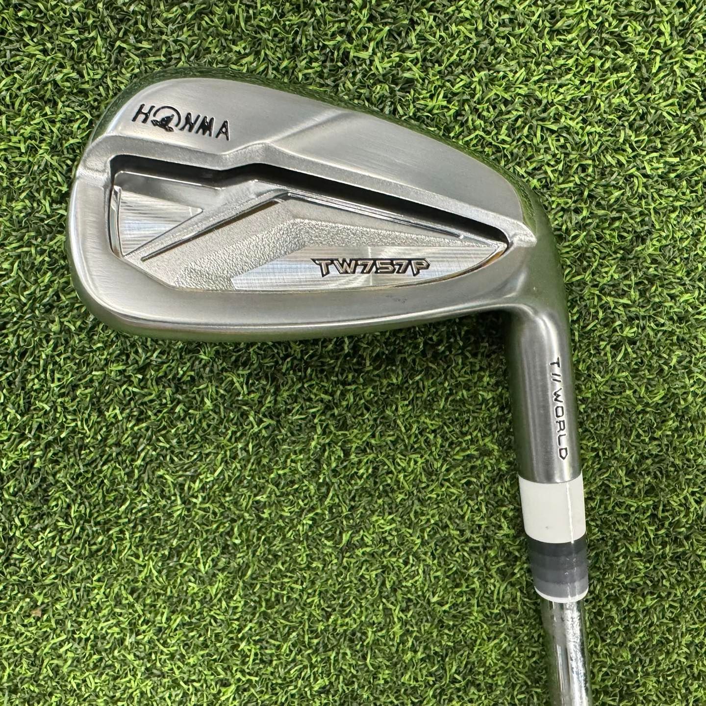 A bunch of golf clubs are lined up on the floor