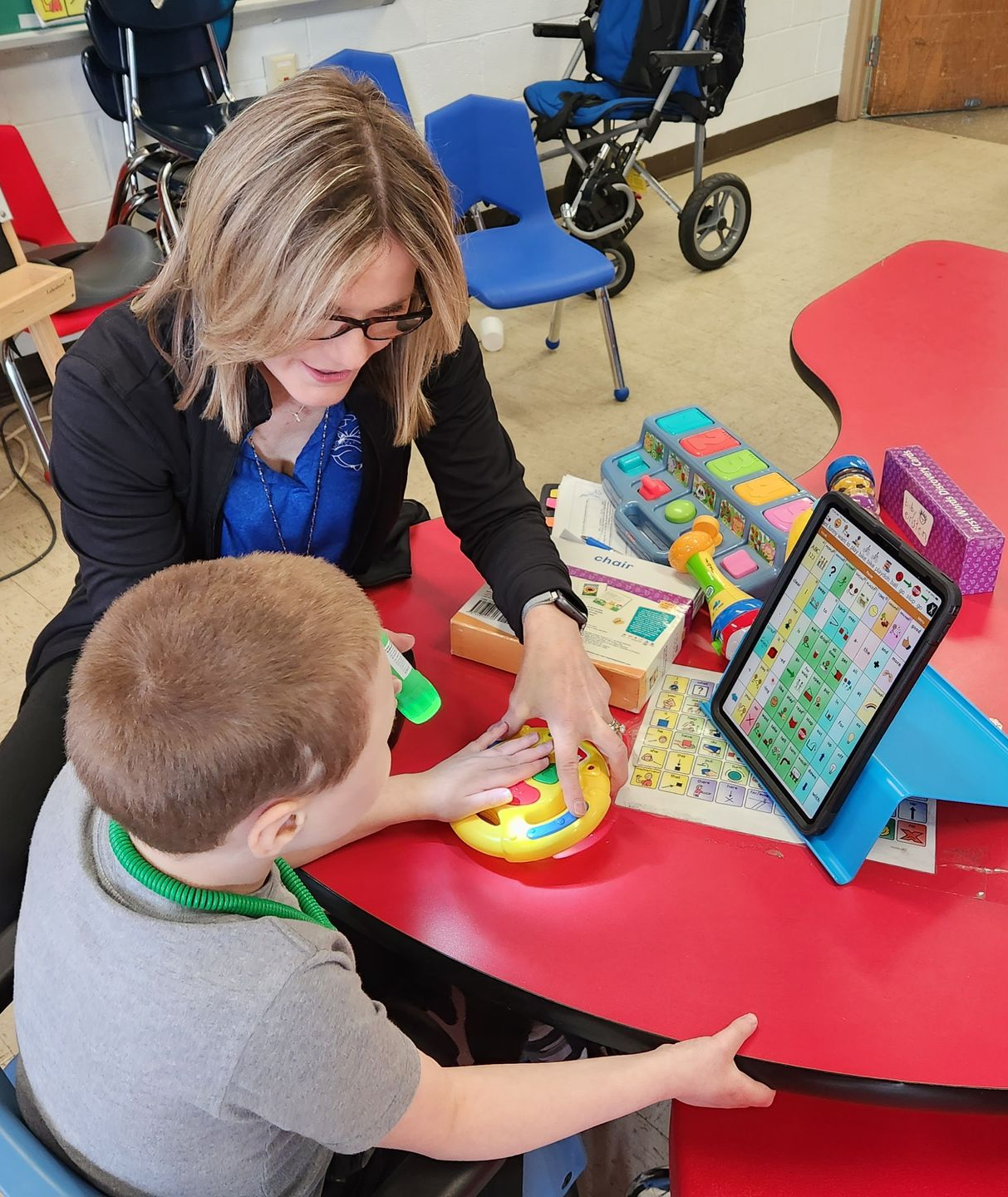 A speech therapist engages with a child in a therapy session.