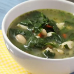 Bowl of spinach and white bean soup with a yellow napkin.