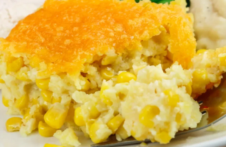 Corn casserole, golden brown crust, served with mashed potatoes.