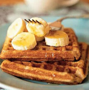 Waffles topped with sliced bananas on a blue plate.