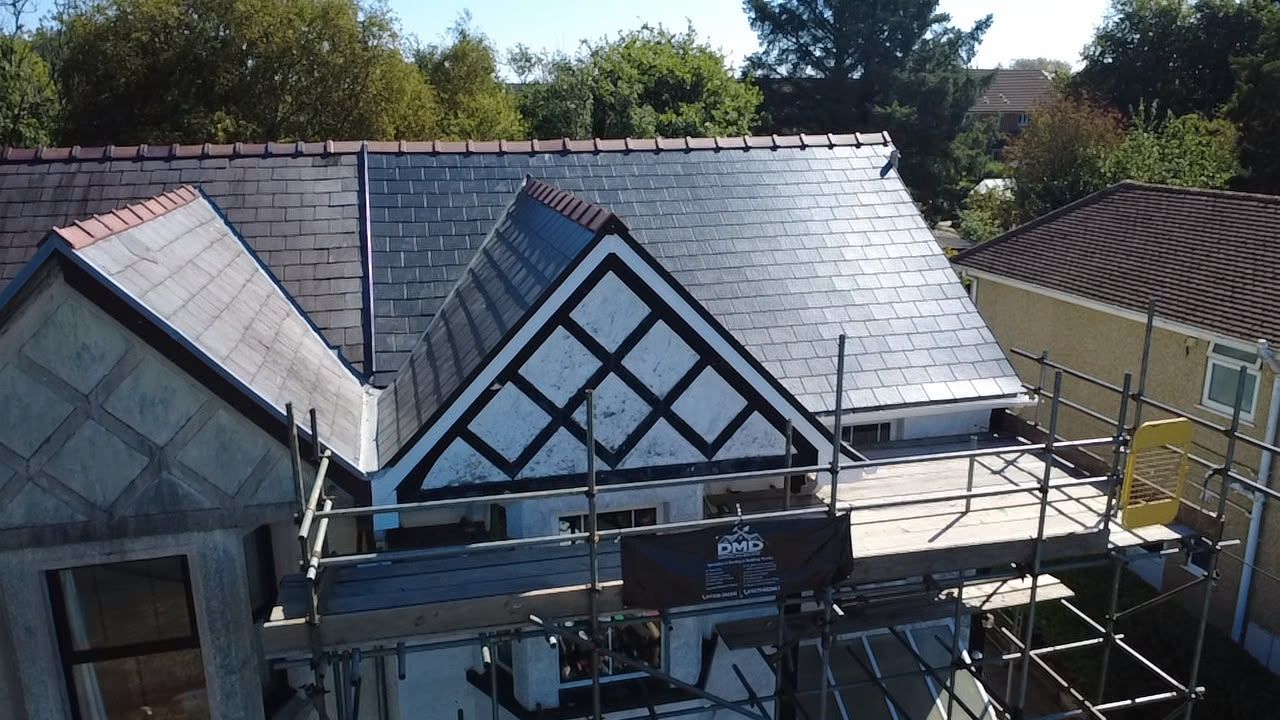 House roof under construction with scaffolding and exposed gables under a clear sky