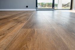 Empty room with wood plank floor and sliding glass doors letting in daylight