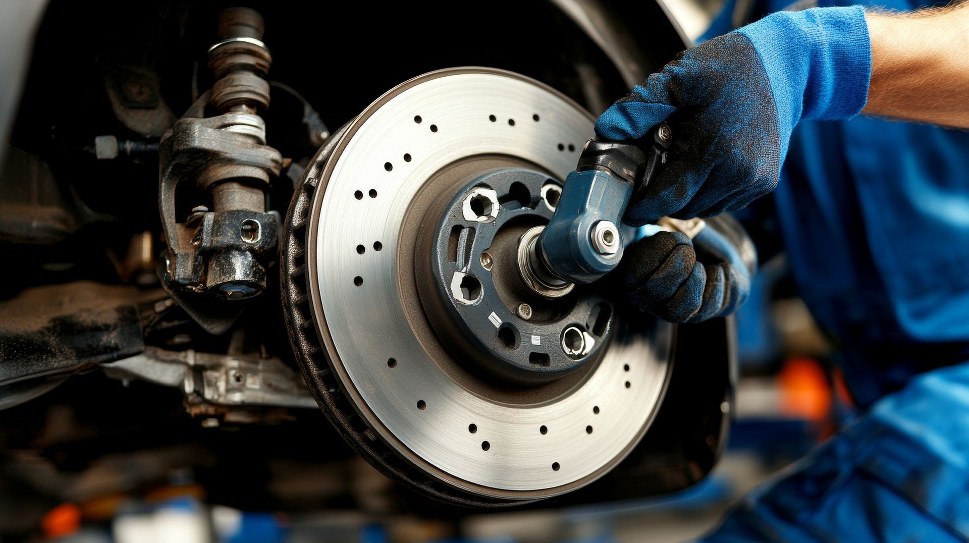 A mechanic is working on a brake disc on a car.