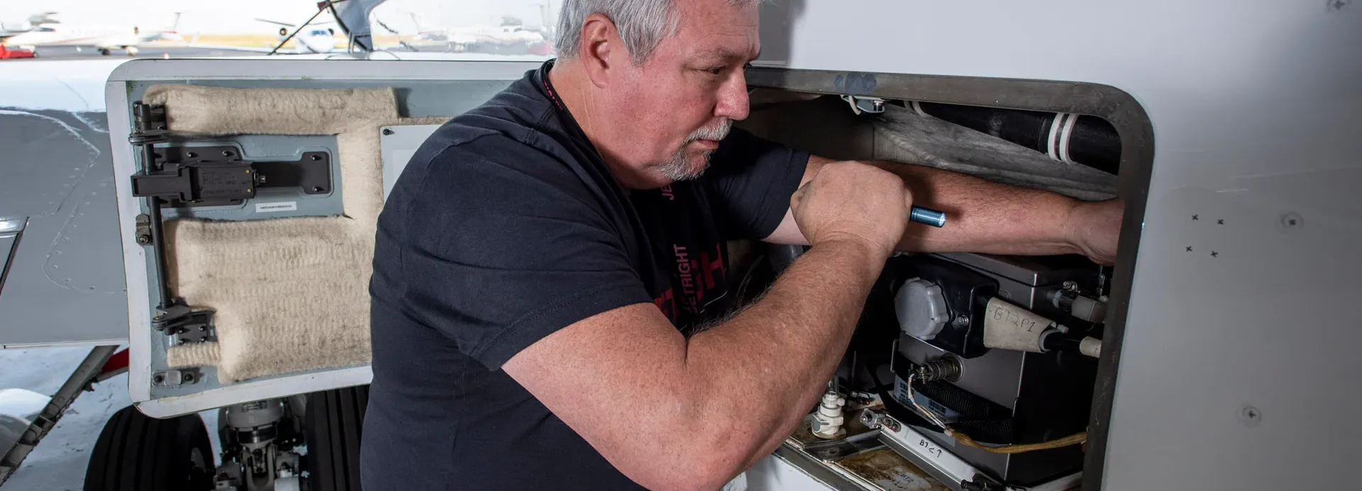 Technician working inside an open aircraft panel - Nashville, Tennessee | JetRight Aerospace Holdings