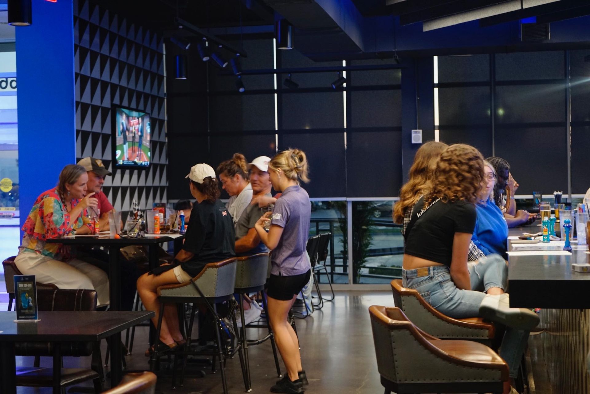 A group of people are sitting at tables in a restaurant.