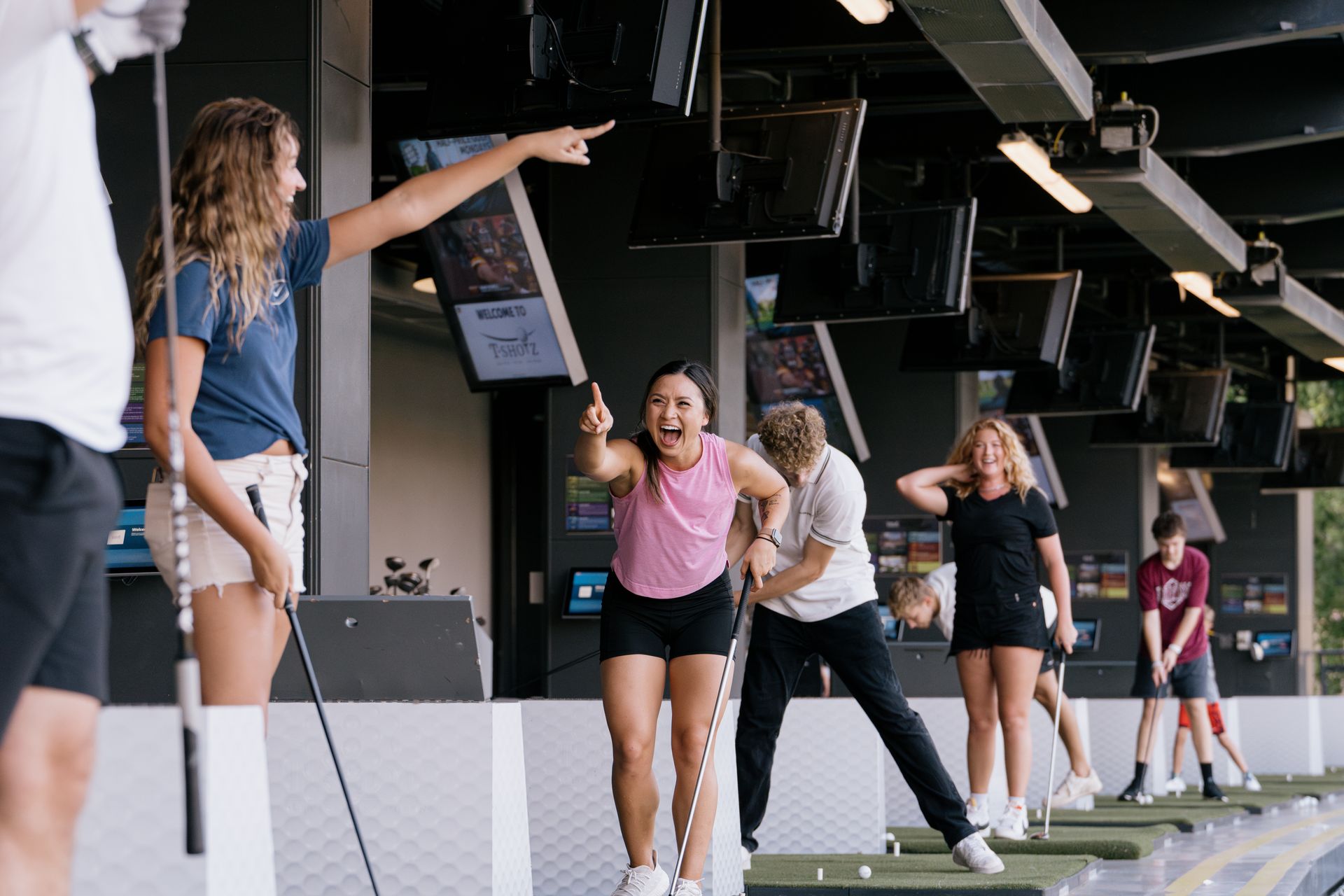 A group of people are playing golf in a gym.