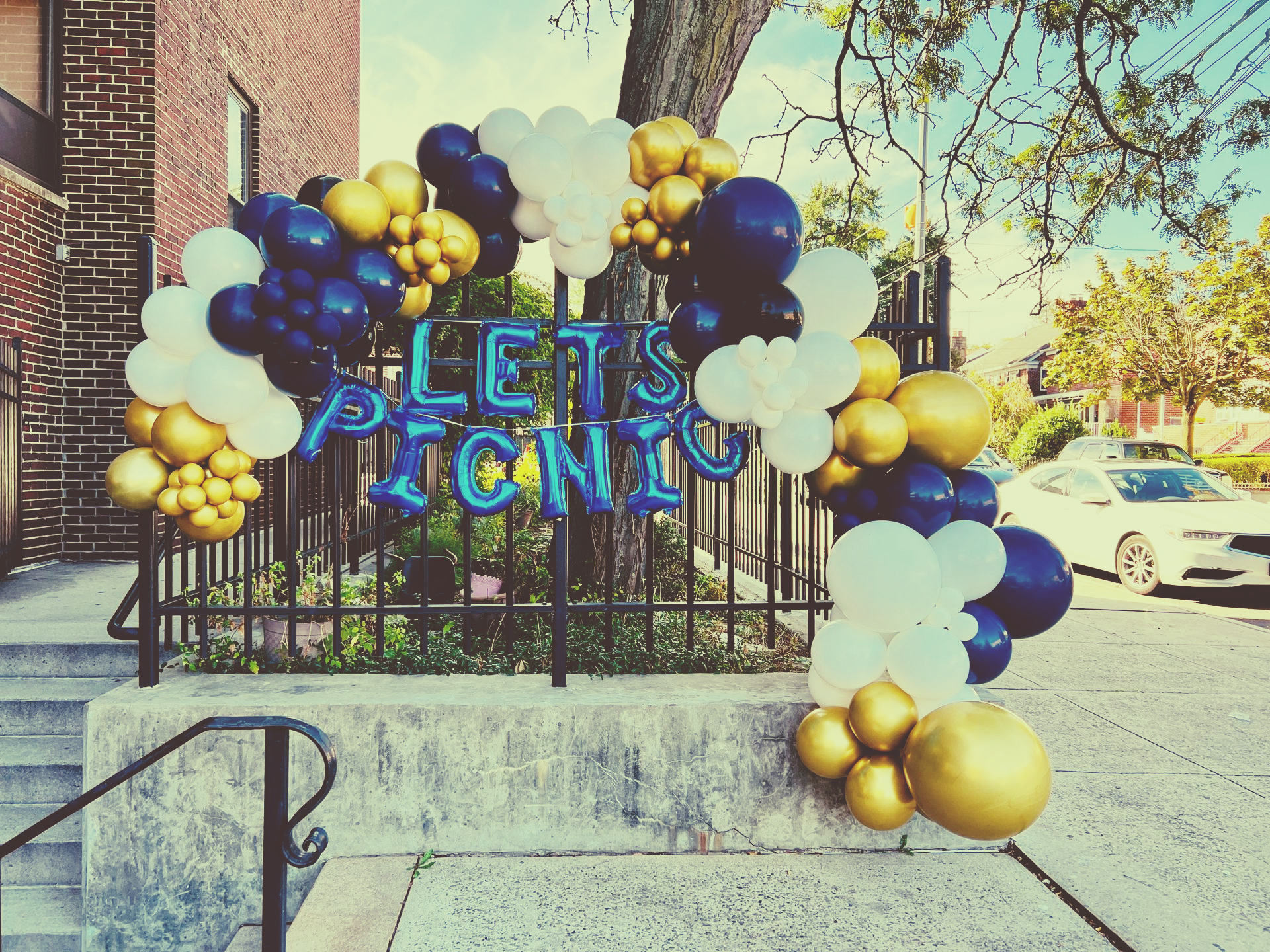 Blue, white, and gold balloon arch framing a
