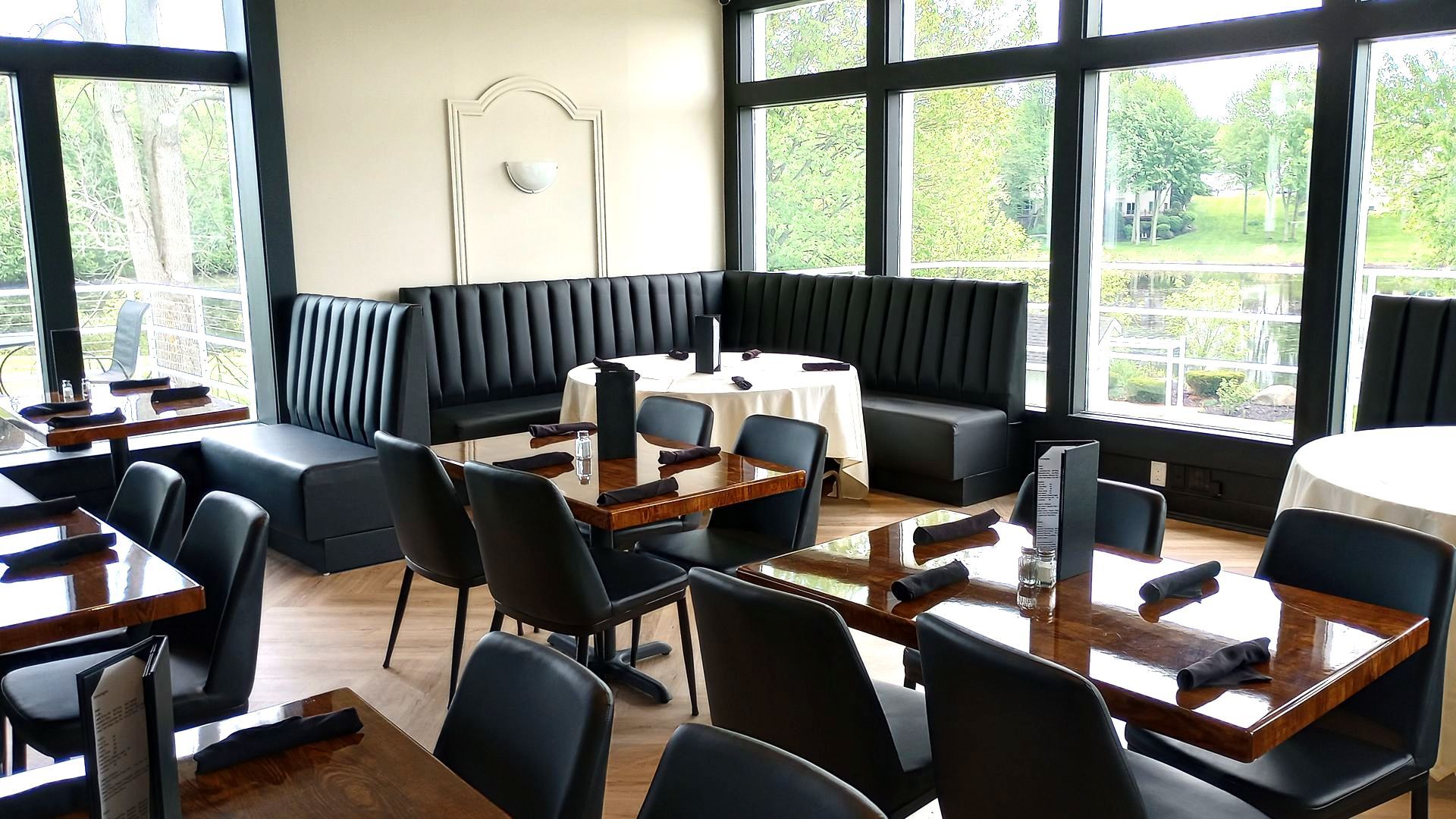 A restaurant with tables and chairs and a lot of windows.