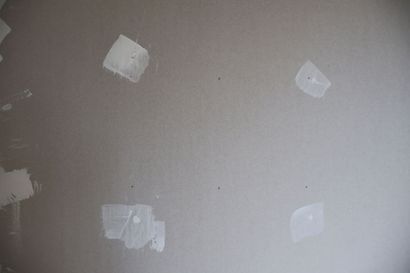 Gray wall with several white patch spots on the surface
