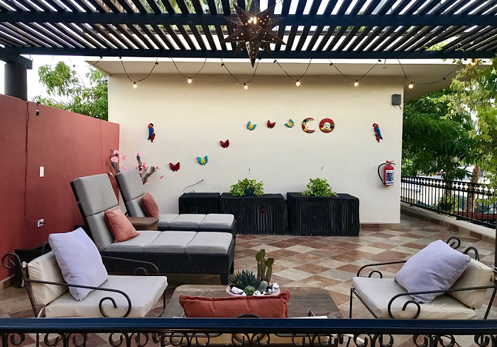 A patio with chairs , a table and a fire extinguisher.