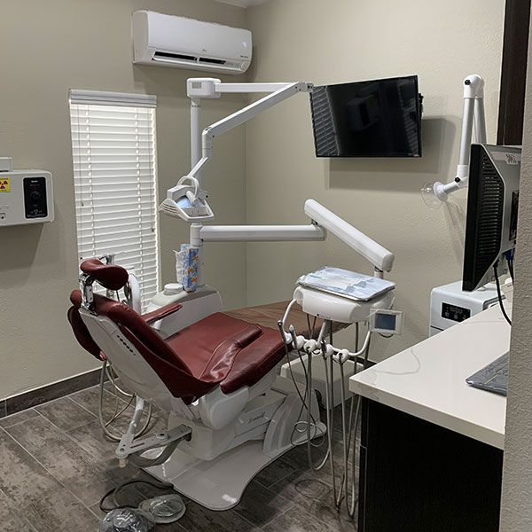 A dental office with a dental chair and a monitor