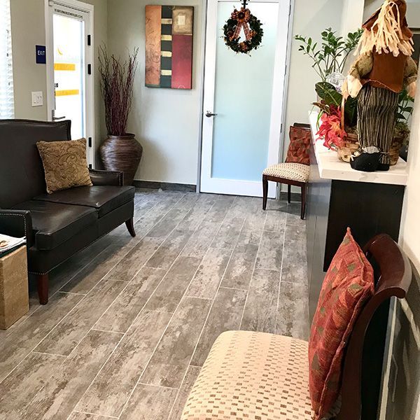 A waiting room with a couch, chairs, and a door