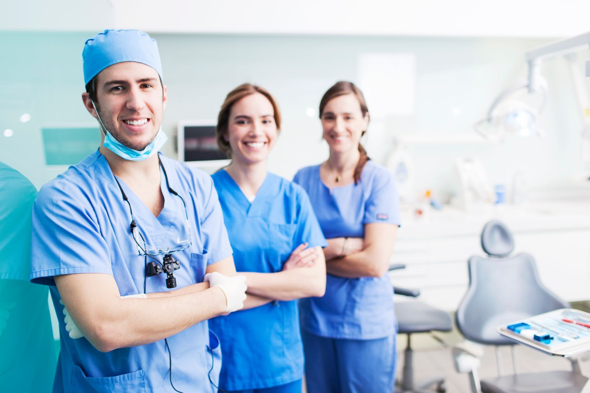 A group of dentists and nurses are posing for a picture in a dental office.