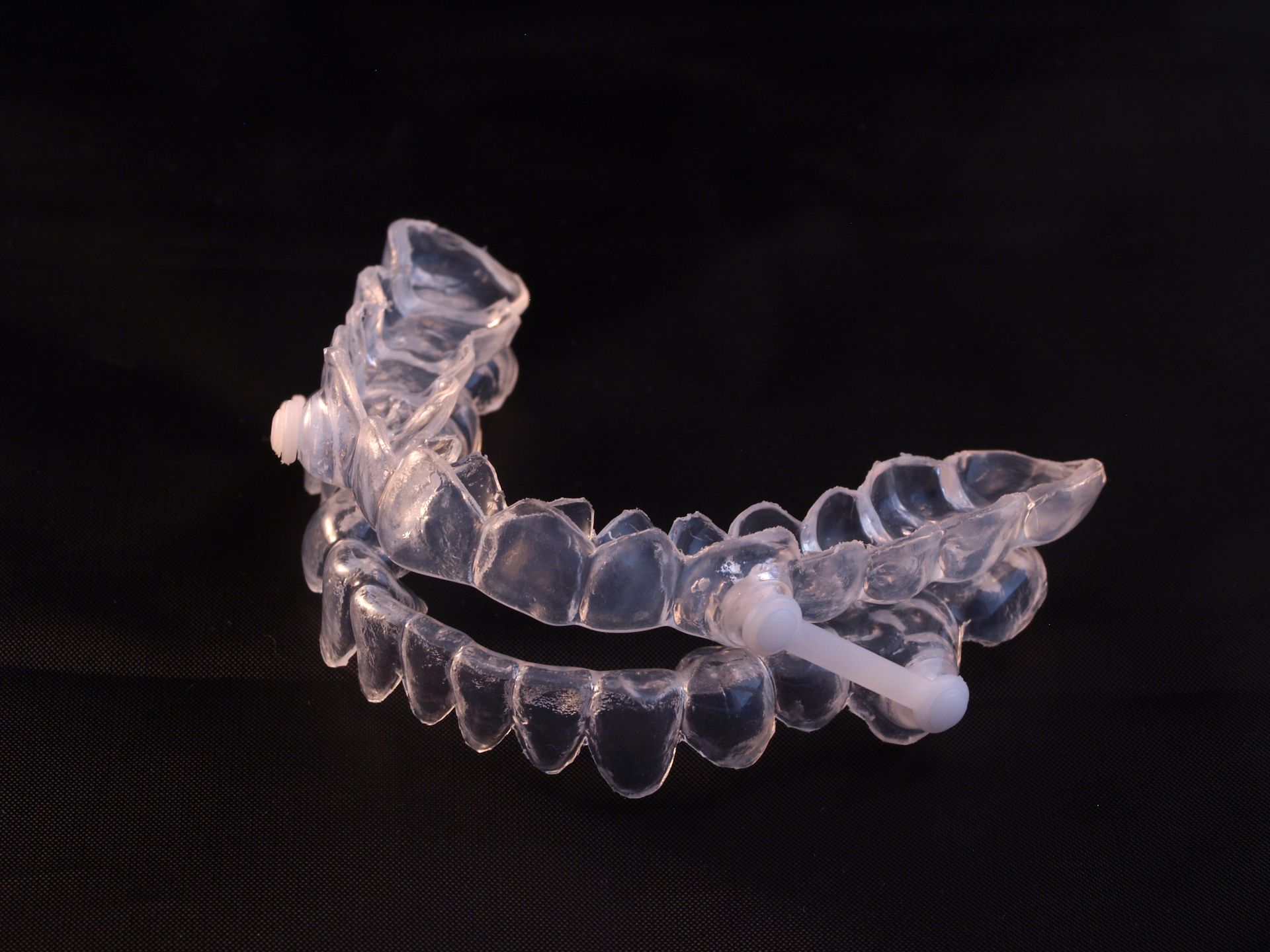 A clear plastic mouthpiece with a white rubber stopper attached to it A clear plastic mouthpiece with a white rubber stopper attached to it
