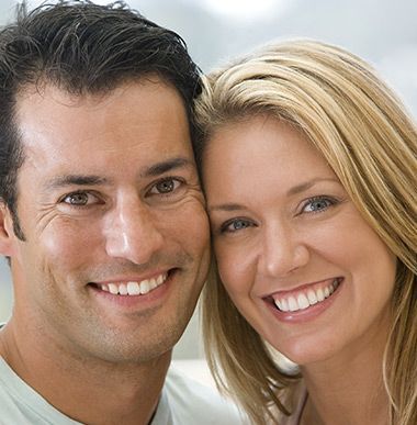 A man and a woman are smiling for the camera A man and a woman are smiling for the camera