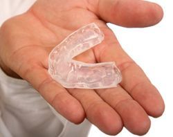 A person is holding a clear mouth guard in their hand A person is holding a clear mouth guard in their hand