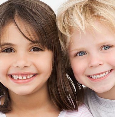 A boy and a girl are smiling for the camera A boy and a girl are smiling for the camera