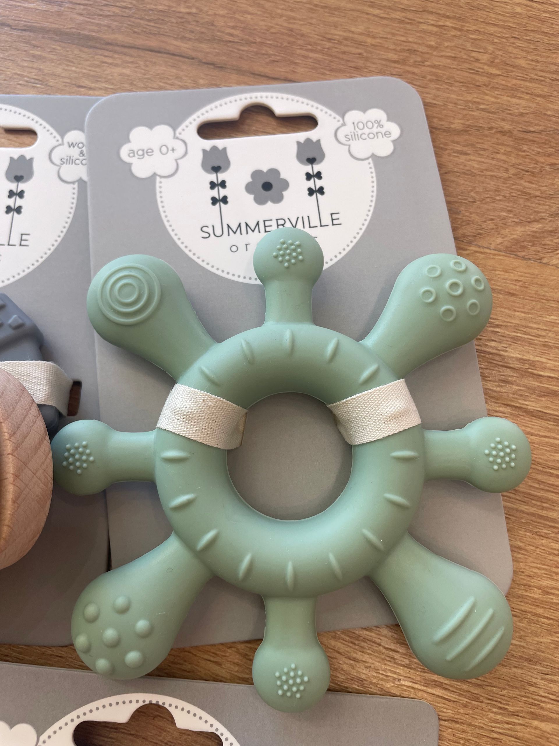 Giocattolo da masticare per cani a forma di stella marina color verde menta, con zampe testurizzate, su un cartoncino espositivo