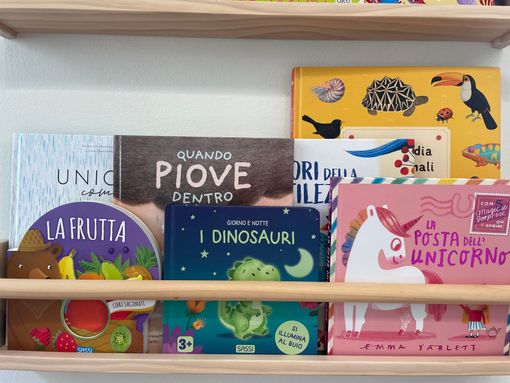 Libreria di libri per bambini colorati su scaffale di legno