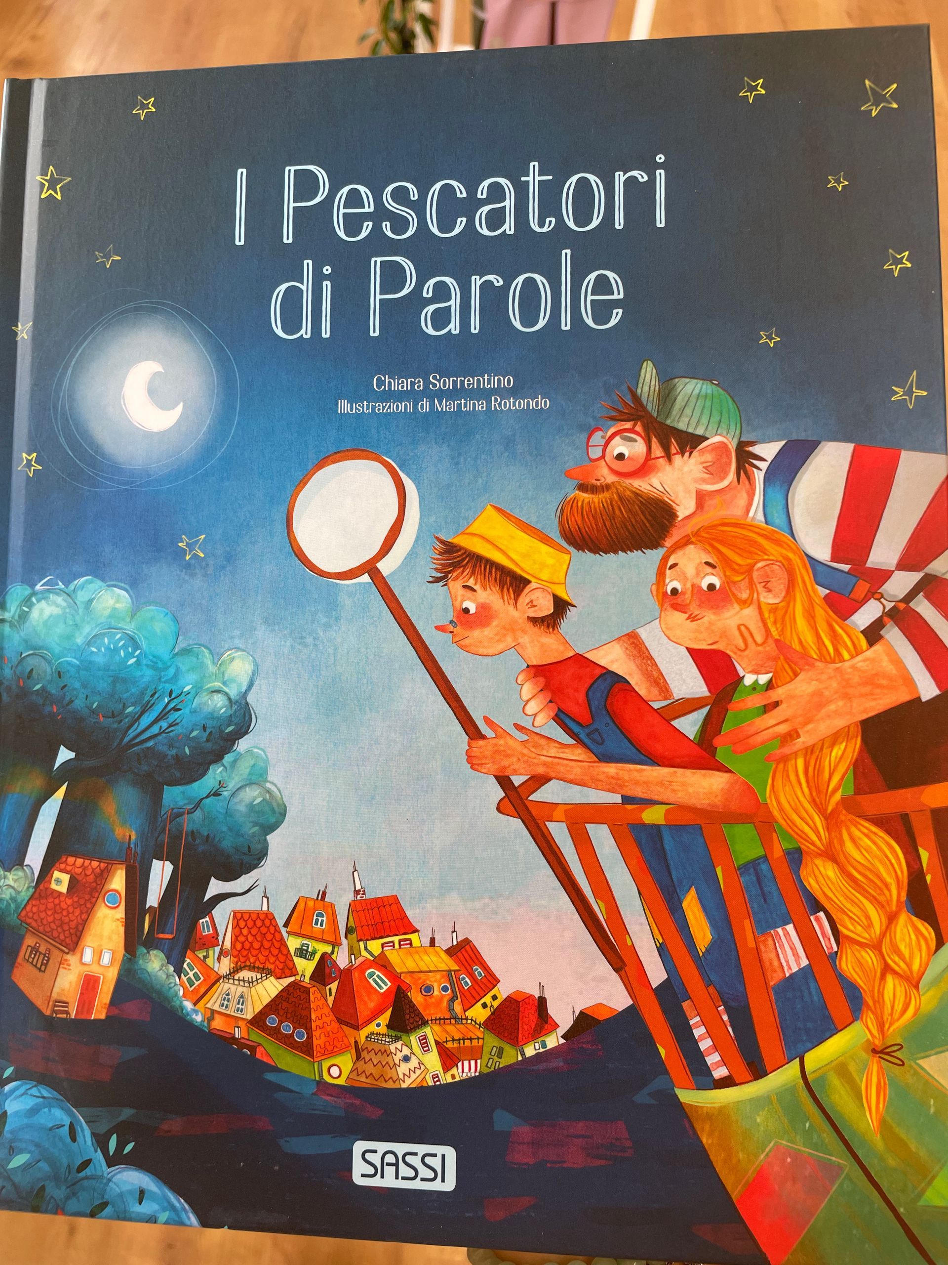 Copertina del libro «I Pescatori di Parole», con bambini che pescano parole con una rete sotto un cielo illuminato dalla luna