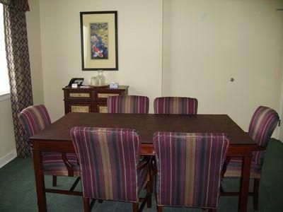 Dining room with a dark wood table, striped chairs, a sideboard, and framed wall art.