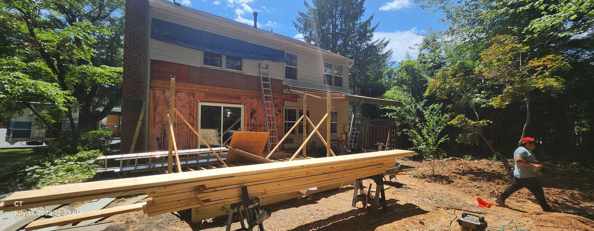 A large wooden structure is being built in front of a house.