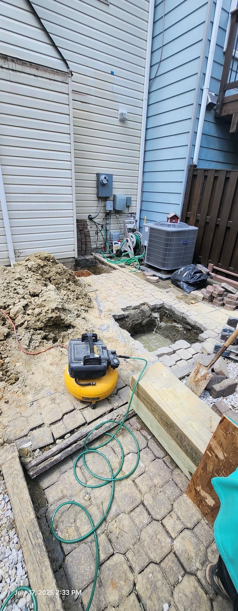 A drainage system is being installed in the backyard of a house.